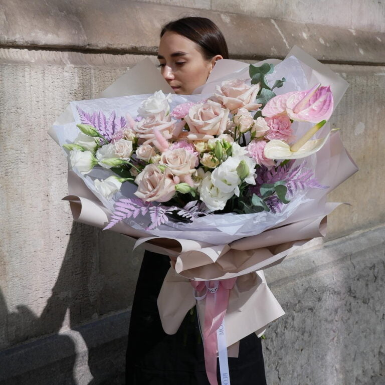 Dziewczyna stoi na tle budynku z dużym bukietem kwiatów