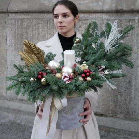 Duży świąteczny box z żywego świerku Nobilis dziewczyna trzyma w rękach