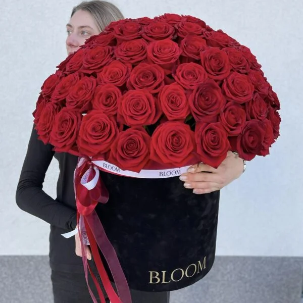 dziewczyna trzyma czarny box z czerwonymi różami