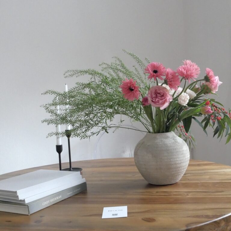Stół na którym stoi wazon z wkaitami